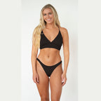 Woman wearing a black bikini on a white background