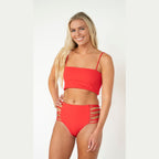 Woman wearing a red bikini set on a white background