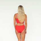 Woman wearing a red bikini set on a white background