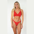 Woman wearing a red bikini against a white background