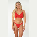 Woman wearing a red bikini against a white background