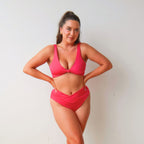 Woman wearing a pink bikini against a plain background